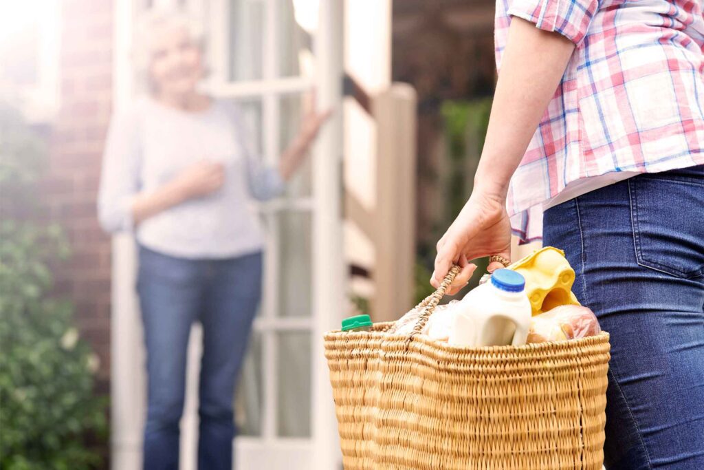 A person holding onto a basket full of food