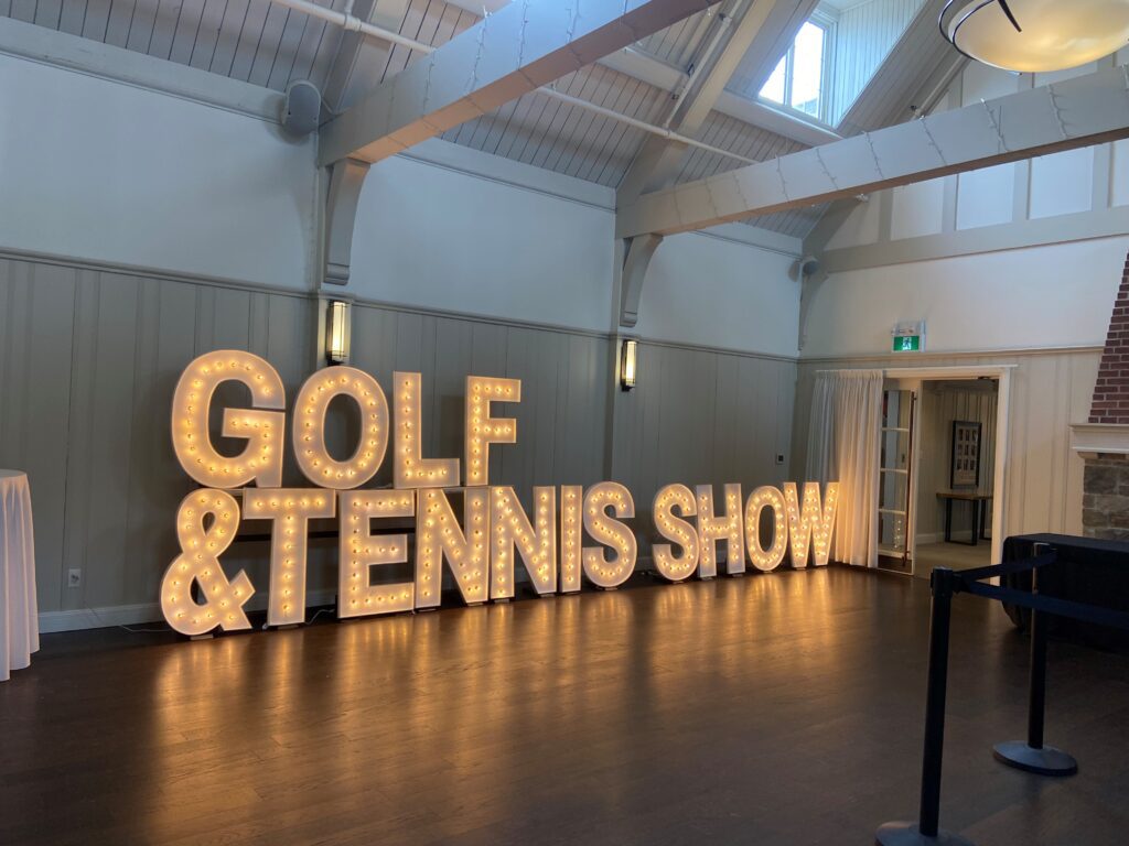 A large sign that says golf and tennis show.