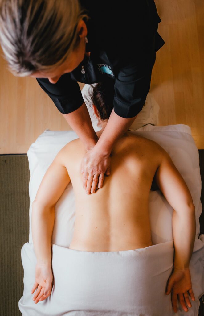 A person is getting their back worked on the massage table.