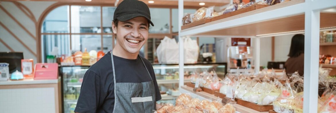 A man holding a tray of food in front of shelves.