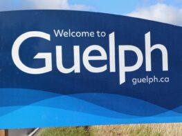 A blue and white sign that says welcome to guelph.